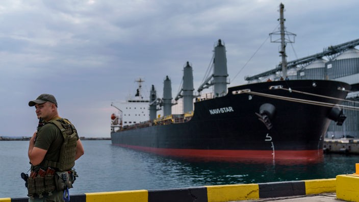 Ein Sicherheitsbeamter steht neben dem Schiff «Navi-Star», das seit dem Beginn der russischen Invasion in die Ukraine mit Getreide beladen ist und darauf wartet, den Hafen von Odessa zu verlassen.