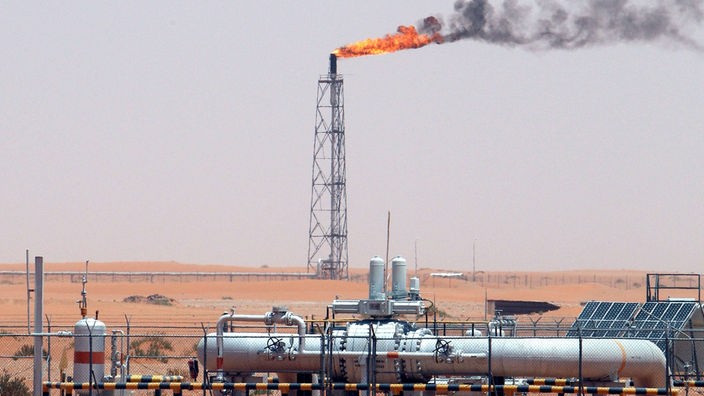 Ölfeld in Saudi-Arabien, aus einem Turm tritt Feuer aus und eine dunkle Rauchwolke