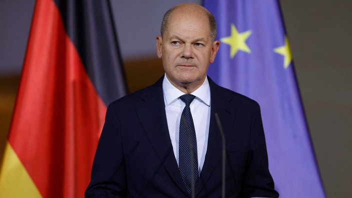 Olaf Scholz vor der Fahne der Europäischen Union