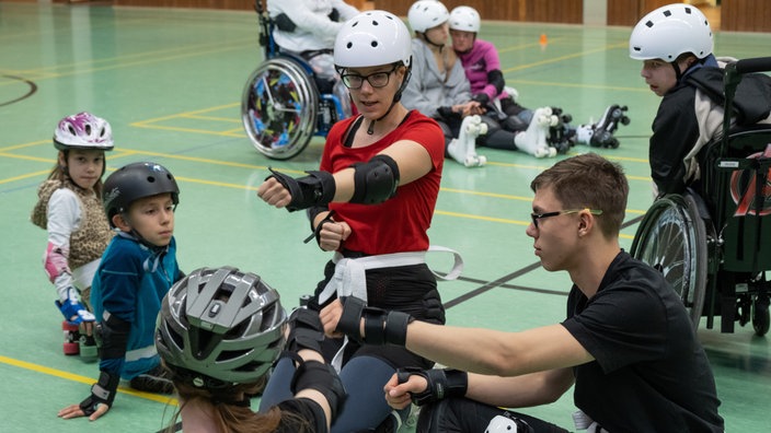 Kinder und Jugendliche mit und ohne Behinderung mit Rollstühlen und Rollschuhen im Integrativen Sportverein Stolberg