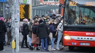 Passagiere stehen Schlange vor einem Bus in Münster