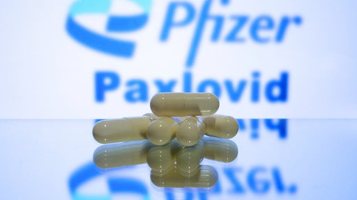 Tabletten-Kapseln vor einem Firmenlogo
