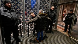 Polizisten kontrollieren am Eingang des Kölner Doms jeden Besucher der Frühmesse am 24.12.2023
