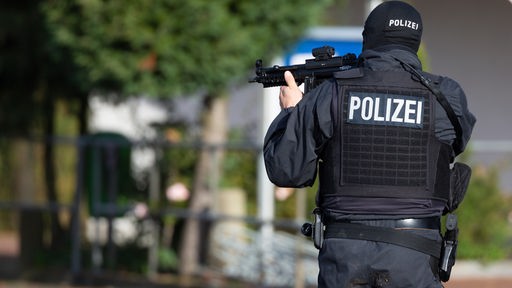 Polizeibeamter mit schusssicherer Weste und Maschinenpistole