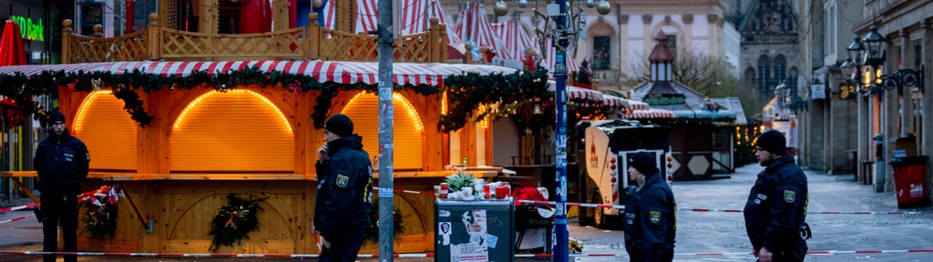 Polizisten gehen am Sonntagmorgen vor dem Magdeburger Weihnachtsmarkt