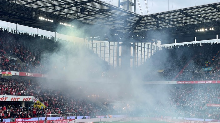 Eine große Rauchwolke im Fußballstadion. 