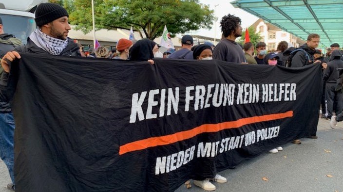 Demonstranten halten ein Banner mit der Aufschrift "Kein Freund kein Helfer".