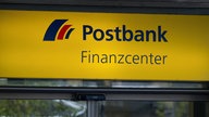 Das gelbe Schild zeigt das Logo der Postbank, darunter steht "Finanzcenter"