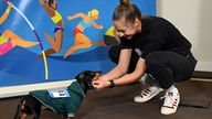 Gina Lückenkemper, Sprint-Europameisterin 2022, streichelt vor einer Pressekonferenz ihren Dackel Akira