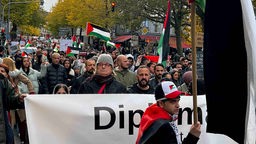 Demonstrierende auf einer Pro-Palästina Demo in Aachen mit Palästina Flaggen, Schildern und Transparenten
