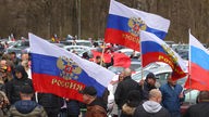 Demonstranten stehen mit russischen Fahnen auf dem Tänzelfestplatz. Der Platz ist Ausgangspunkt eines prorussischen Autokorsos. 