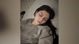 Selin Islami liegt mit geschlossenen Augen in einem Krankenhausbett