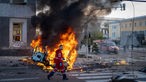  Ein Sanitäter geht an einem brennenden Auto nach einem russischen Angriff vorbei.