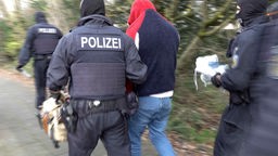 Die Polizei nimmt im Rahmen der Schleuser-Razzia in Köln einen Mann fest
