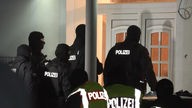 Beamte der Polizei stehen vor einer Haustür