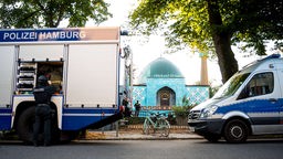Einsatzkräfte der Polizei stehen während einer Razzia vor dem Gelände vom Islamischen Zentrum Hamburg (IZH) mit der Imam Ali Moschee (Blaue Moschee) an der Außenalster