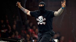 Serbischer Hooligan mit Totenkopf-Aufdruck auf dem Shirt in agressiver Pose