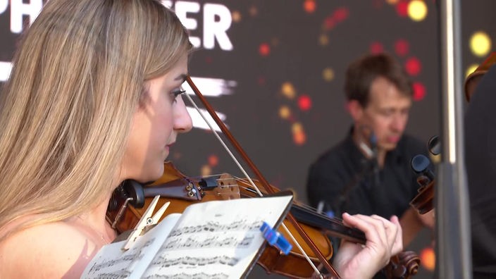 Nahaufnahme einer Geigenspielerin der Bergischen Symphoniker. Die Symphoniker spielen auf einer Bühne auf dem Sommerfest in Solingen.