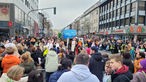 Die Biscmarckstraße ist voll von Zuschauern des Karnevalszugs.