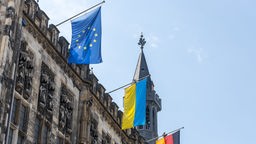 Eine Europaflagge und eine Ukraineflagge hängen vor der Fassade des Aachener Rathauses