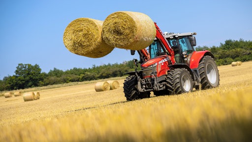 Traktor mit Heu auf einem Feld