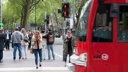 Menschen stehen an einer roten Ampel