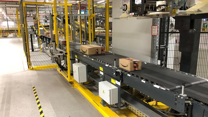 Zwei Amazonpakete werden mit dem Laufband transportiert