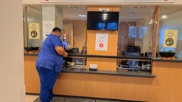 Ein Pfleger steht am Schalter einer Zentrale Notfallambulanz 