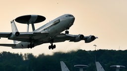Ein graues AWACS-Boeing-Aufklärungsflugzeug der NATO startet in der Dämmerung vom Flughafen Geilenkirchen