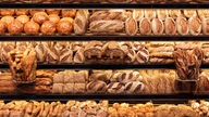 Symbolbild: Eine Auslage einer Bäckerei mit Brötchen und Broten. Auch die Bäckerei-Branche steht aktuell unter Druck.