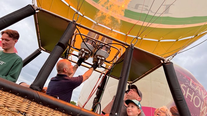 Ein Pilot heizt seinen Heißluftballon an 