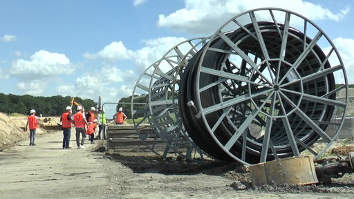 Auf einer Baustelle sind neben Bauarbeitern ebenfalls Speicherradtrommeln zu sehen 