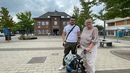David Welschoff mit seiner Mutter Sabine Bordych (mit Rollator) vor dem Bahnhof