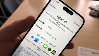 Ein Handy auf dessen Bildschirm unter anderem das Wort "Apfel ID" zu sehen ist