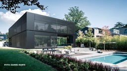 Eine Luxusvilla bestehend aus einem filigranen Stahlskelettbau, großen Fenstern und einer schwarzen, textilen Haut