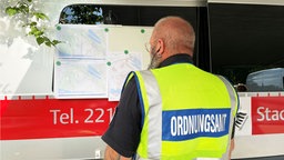 Ein Mitarbeiter des Ordnungsamts sieht sich den Radius der Evakuierung an