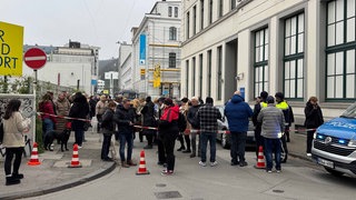 Vor dem Staatsanwaltschaftsgebäude wurde die Straße gesperrt. Viele Menschen stehen vor dem Gebäude.