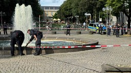 Polizisten untersuchen das Gelände am Busbahnhof in Bonn