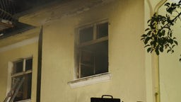 Ein ausgebranntes Fenster eines Wohnhauses.