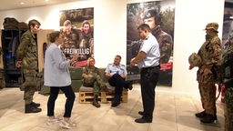 Bundeswehr Soldatinnen und Soldaten wie sie an ihrem Stand miteinander sprechen