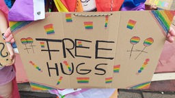 Amanda hält ihr "Free Hugs"-Schild in der Hand