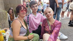 Lissy (r.), Noah und Kira sitzen beim CSD in Köln