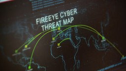 Auf einem Bildschirm ist eine Weltkarte zu sehen. Darauf steht "Fire Eye Cyber Threat Map".