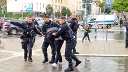 Polizisten nehmen in Düsseldorf einen Protestler in Gewahrsam.