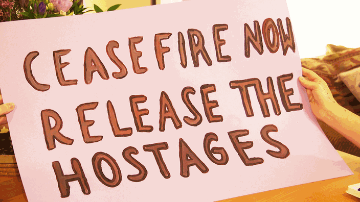 Ein gemaltes Plakat für die Demo, auf dem der Satz gefordert wird: Cease Fire now Release the Hostages