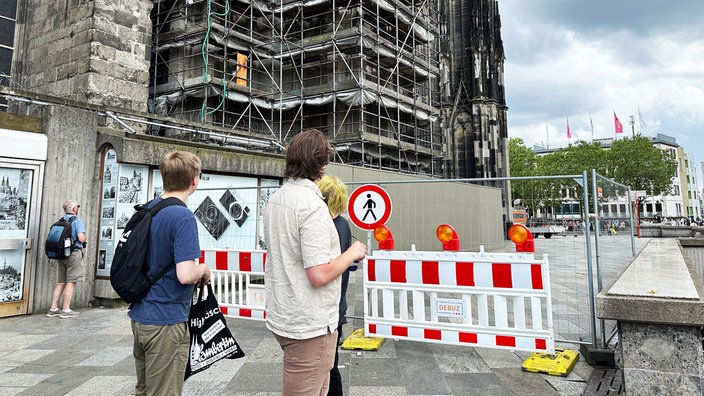 Menschen stehen vor der gesperrten Domplatte