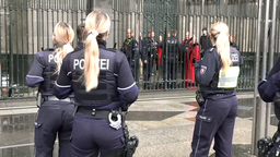 Polizistinnen vor einem Zaun des Kölner Doms. Geistliche und Uniformierten stehen hinter dem Zaun. 