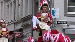 Ein Gardemädchen in rot-weißer Uniform wird in der Luft gehalten