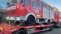 Ein Feuerwehrauto ist auf einem Anhänger befestigt