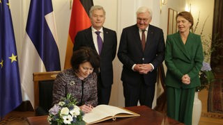 Die Frau des finnischen Präsidenten schreibt ins Goldene Buch der Stadt Bonn